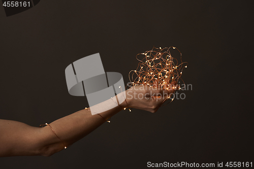 Image of bright christmas lights in woman\'s hands