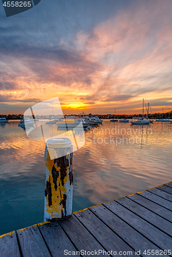 Image of Beautiful sunset across the bay with moored yachts and boats