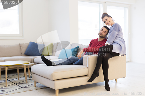 Image of couple hugging and relaxing on sofa