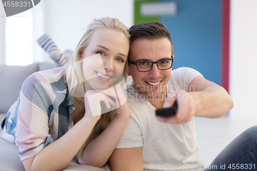 Image of Young couple on the sofa watching television