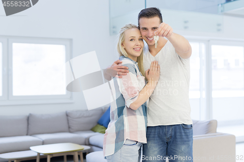 Image of couple showing a keys of their new house