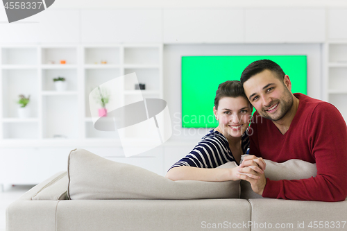 Image of couple hugging and relaxing on sofa