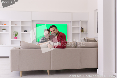 Image of couple hugging and relaxing on sofa