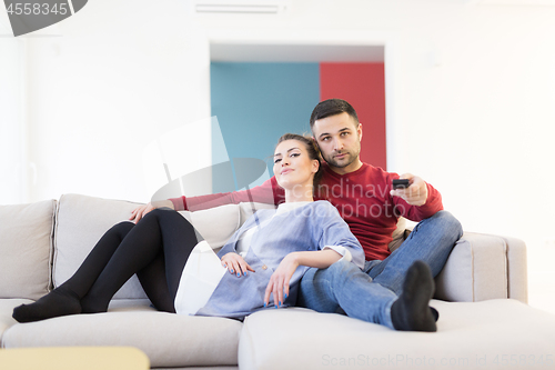 Image of Young couple on the sofa watching television