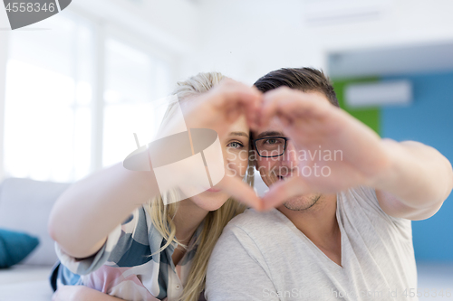 Image of couple making heart with hands