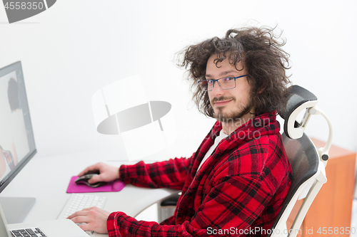 Image of graphic designer in bathrobe working at home