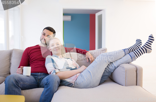 Image of couple hugging and relaxing on sofa