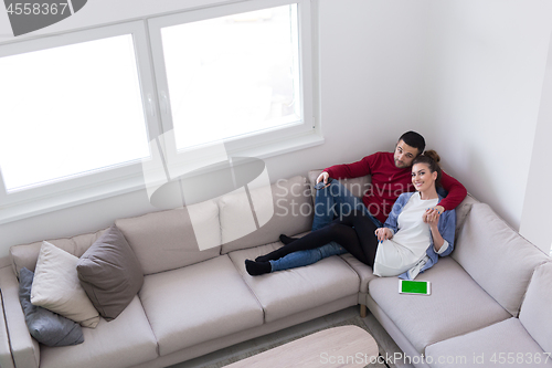 Image of Young couple on the sofa watching television