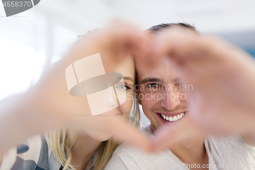 Image of couple making heart with hands