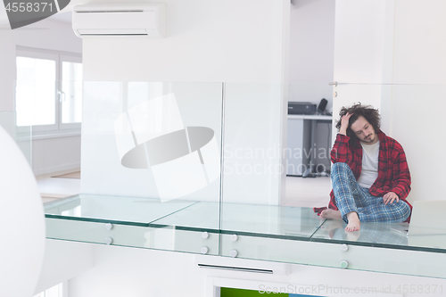 Image of young freelancer in bathrobe working from home