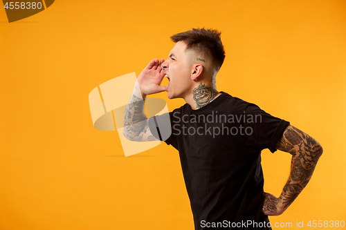 Image of young casual man shouting at studio