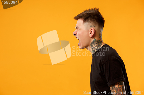 Image of The young emotional angry man screaming on studio background