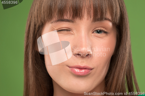 Image of Close up portrait of a pretty young woman winking