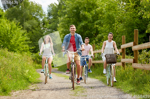 Image of happy friends riding fixed gear bicycles in summer