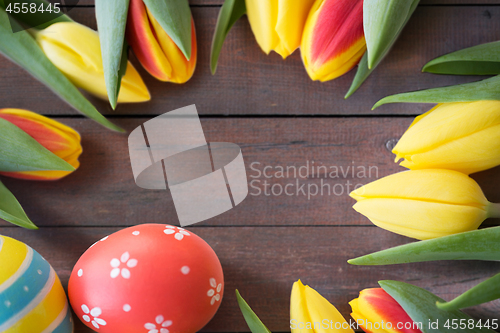 Image of close up of colored easter eggs and tulip flowers