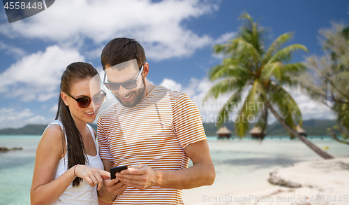 Image of happy couple with smartphone in summer