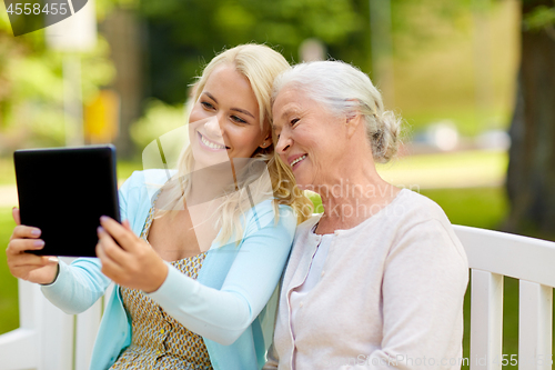 Image of daughter with tablet pc and senior mother at park