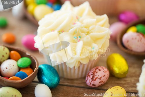 Image of cupcake with chocolate eggs and candies on table