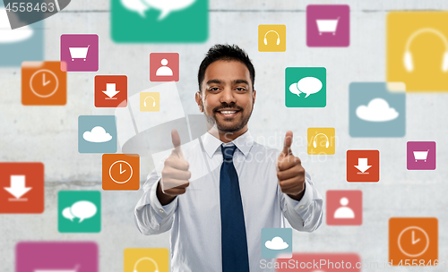 Image of indian businessman shows thumbs up over app icons