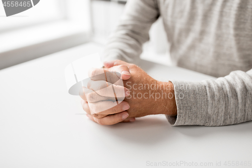 Image of senior man hands on table