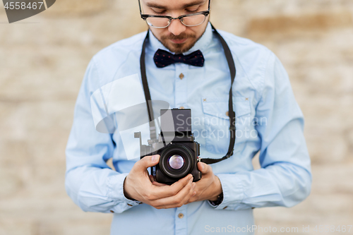 Image of photographer or hipster with film camera outdoors