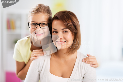 Image of portrait of happy mother and daughter at home