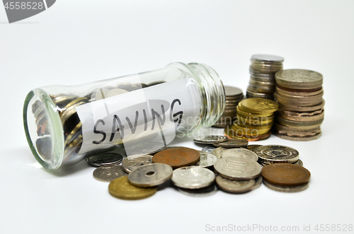 Image of Saving lable in a glass jar with coins spilling out