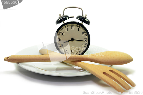 Image of Alarm clock with fork and knife on the plate