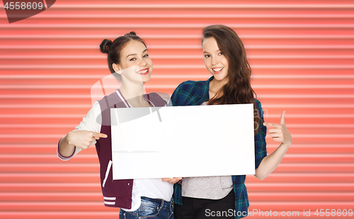 Image of happy teenage girls or friends holding white board
