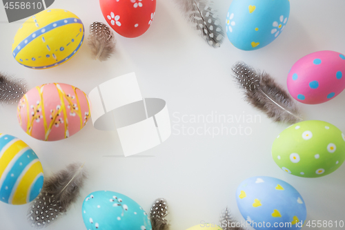 Image of close up of colored easter eggs and feathers