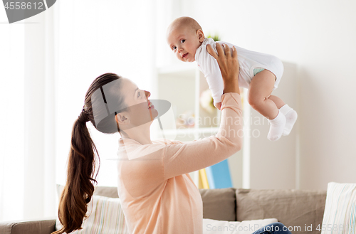 Image of happy mother playing with little baby boy at home