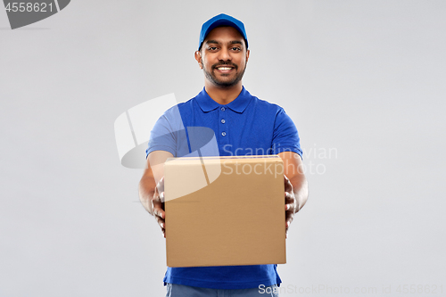 Image of happy indian delivery man with parcel box in blue