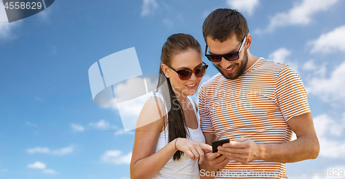 Image of happy couple with smartphone in summer