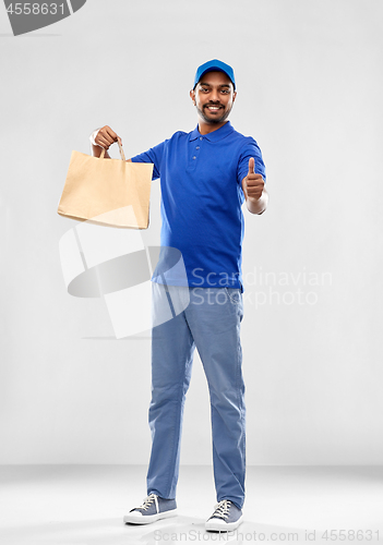 Image of happy indian delivery man with food in paper bag