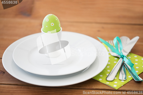 Image of easter egg in cup holder, plates and cutlery