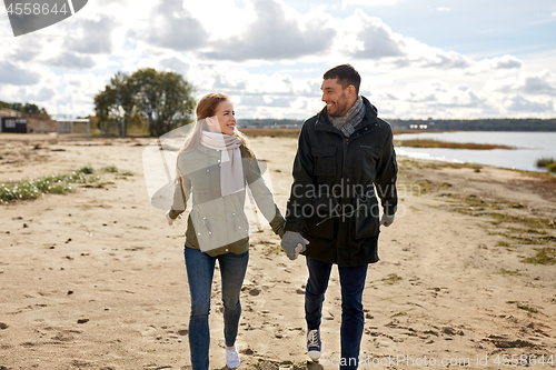 Image of couple walking along autumn beach