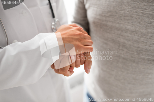 Image of close up of doctor holding senior patient hand