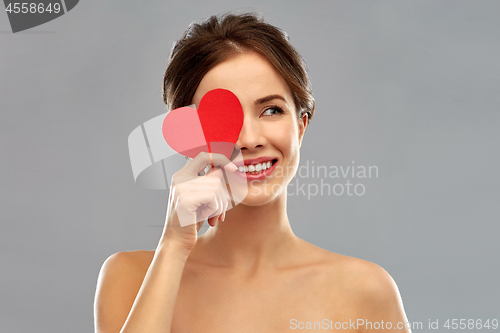 Image of beautiful smiling woman holding red heart