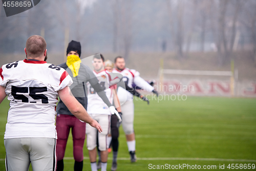 Image of american football players stretching and warming up