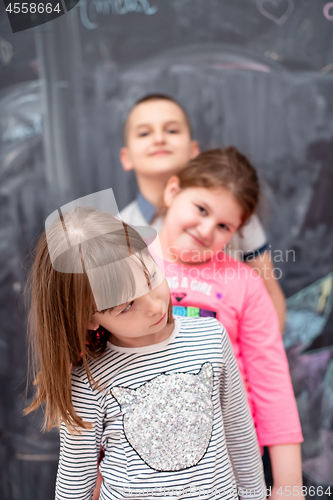 Image of group of kids standing in front of chalkboard