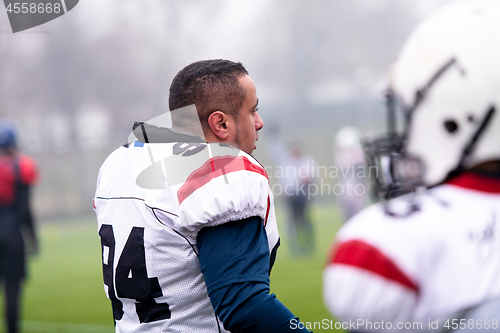 Image of confident American football players leaving the field