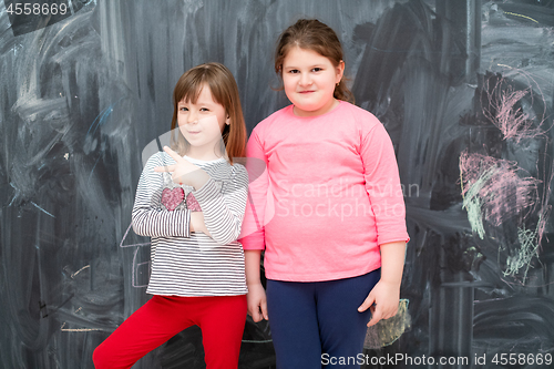 Image of portrait of little girls in front of chalkboard