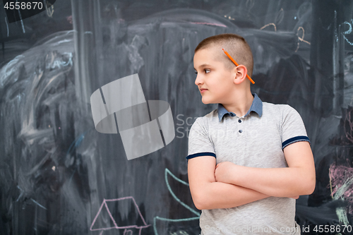 Image of portrait of little boy in front of chalkboard