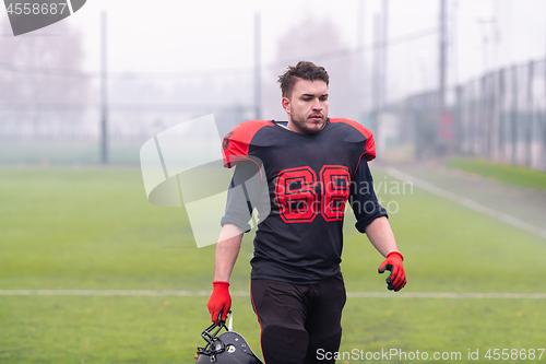 Image of confident American football player leaving the field