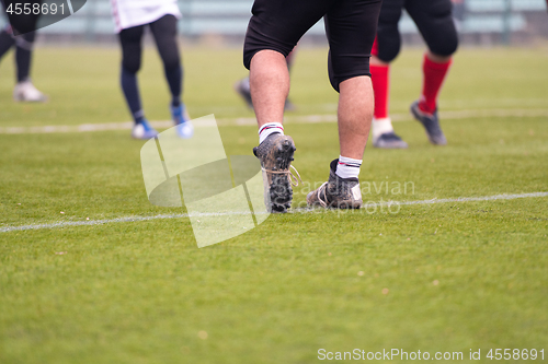 Image of close up of american football players stretching and warming up