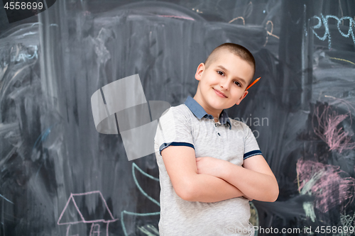 Image of portrait of little boy in front of chalkboard