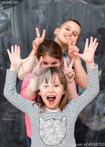 Image of group of kids standing in front of chalkboard