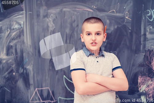 Image of portrait of little boy in front of chalkboard