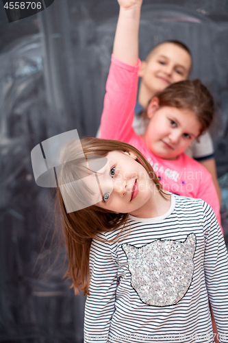 Image of group of kids standing in front of chalkboard