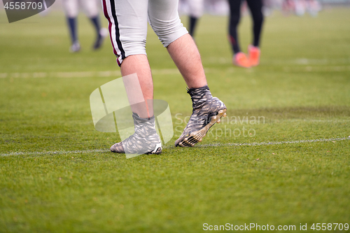 Image of close up of american football players stretching and warming up